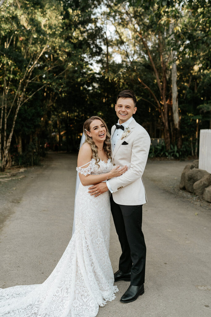 Bride and Groom standing on a gravel driveway laughing during their fun Scenic Rim Wedding Photography Session. 